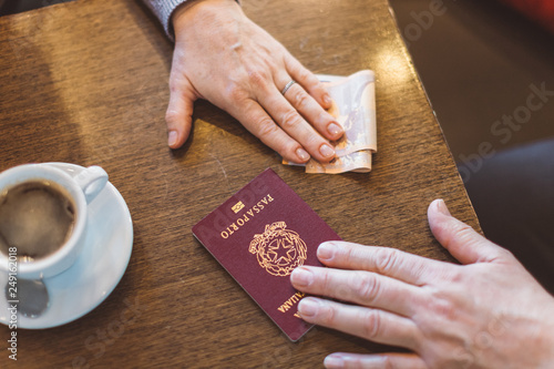 Foto Male and female hands with passport and money on the table - concept of illegal