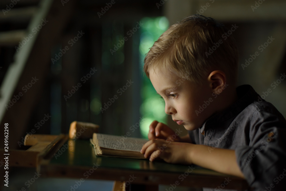 A boy in an old house reading a mysterious book. Fun in search of treasure. A boy in an old house reading a mysterious book. Fun in search of treasure.