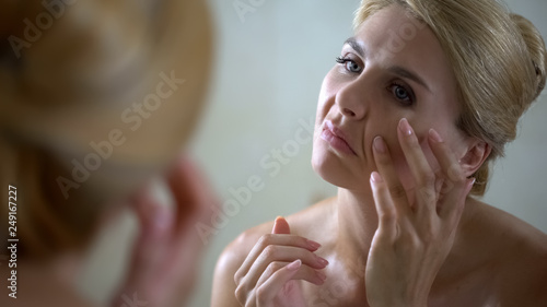 Foto Worried woman trying to smooth wrinkles, face lifting, plastic surgery concept