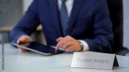 Government budget analyst using tablet pc, checking information in e-documents