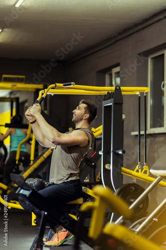 Handsome muscular man working out hard at gym