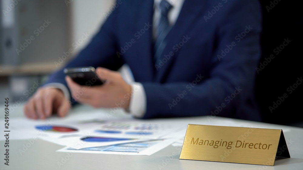 Young managing director using smartphone, working on business market research Young managing director using smartphone, working on business market research