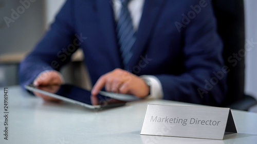 Successful marketing director working on tablet computer, developing media plan photo