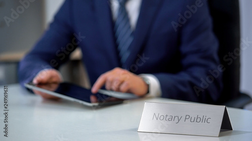 Young notary public working on tablet pc, preparing administrative documents