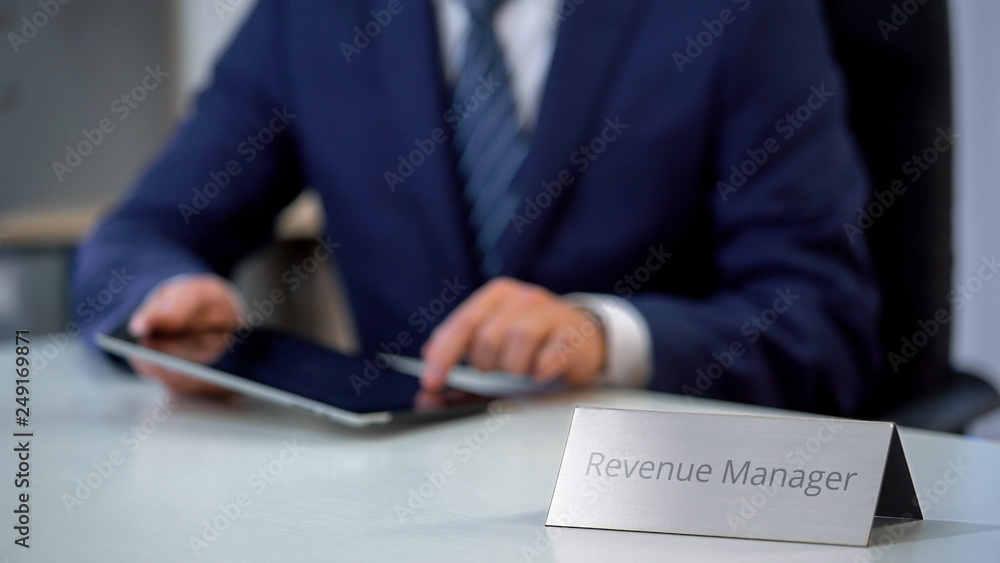 Revenue manager working on tablet pc, reading news about situation on market Revenue manager working on tablet pc, reading news about situation on market