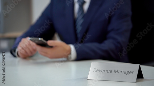 Busy revenue manager using mobile app on smartphone, viewing files on screen