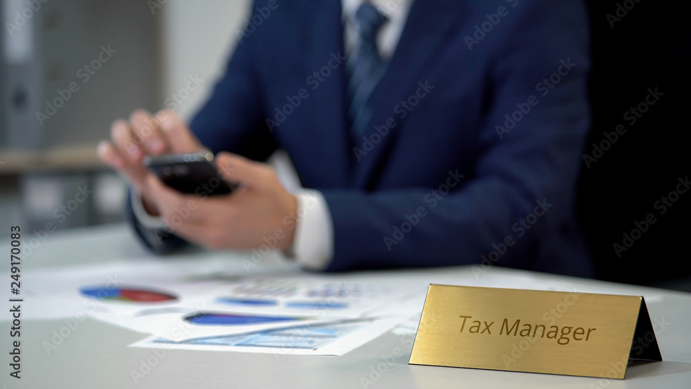 Young manager checking financial data in annual report, using mobile application Young manager checking financial data in annual report, using mobile application