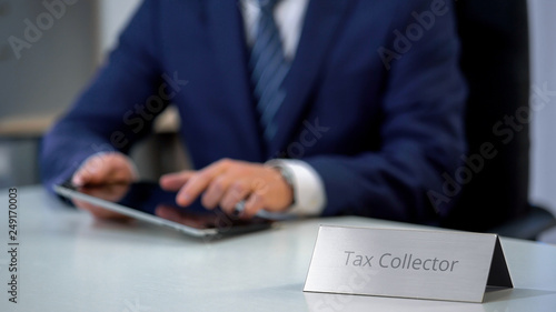 Bild auf Leinwand Tax collector using tablet pc with database of debtors with bad credit history