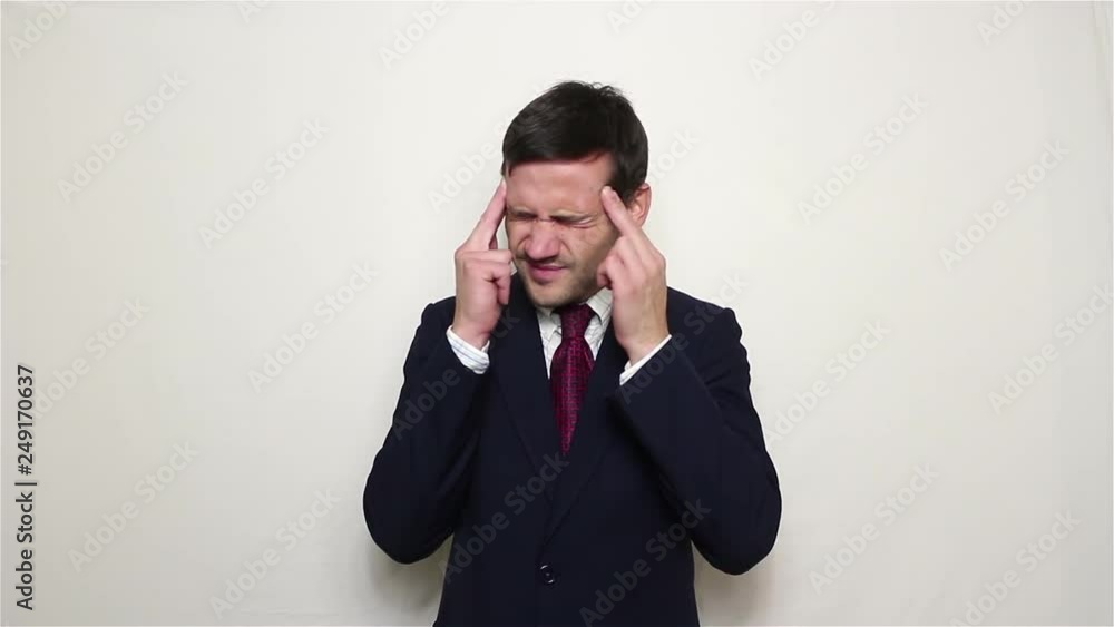 Young handsome businessman in blue suit suffers from headache..Portrait on a white background. Young handsome businessman in blue suit suffers from headache..Portrait on a white background.