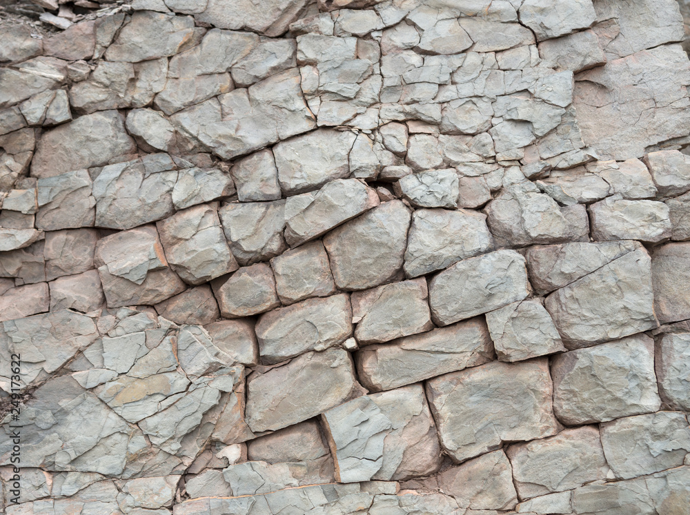 Broken rock in a cliff face. The rock is broken into rectangular shapes, and is weathered and erroded. Broken rock in a cliff face. The rock is broken into rectangular shapes, and is weathered and erroded.