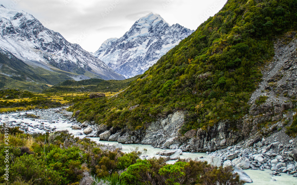 Scenic landscape view of Hooker Valley, Aoraki/Mount Cook National Park, South Island of New Zealand. Snow covered mountains. Tourist (backpackers) popular hiking or walking attraction/destination.