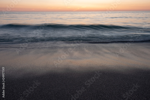 Long exposure of waves on beach at sunset © Liam