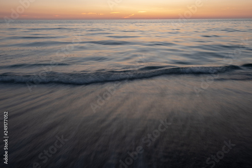 Long exposure of waves on beach at sunset