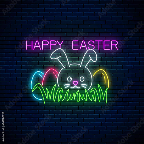 Happy easter glowing signboard with bunny and colored eggs on grass in neon style. Easter funny greeting banner.