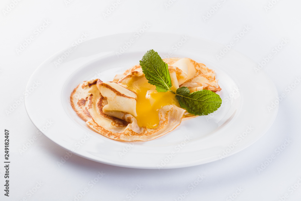 Two pancakes with honey on a white plate on a light background (close) Two pancakes with honey on a white plate on a light background (close)