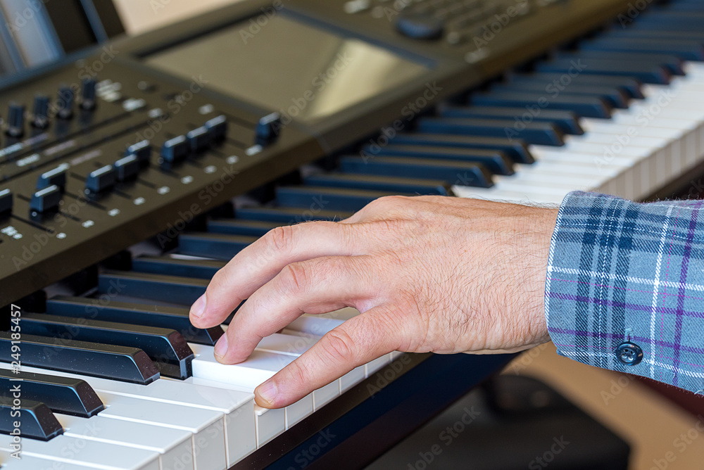 Obraz premium Hands of a man playing the electric piano.