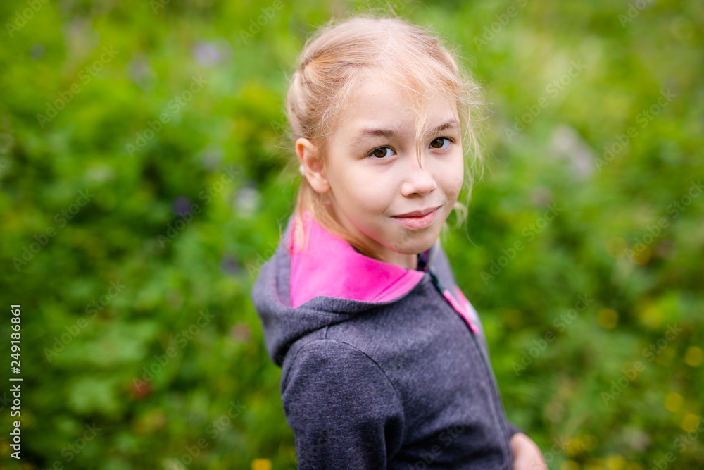 Cute blonde girl in the mountains wearing warm gray jacket Cute blonde girl in the mountains wearing warm gray jacket