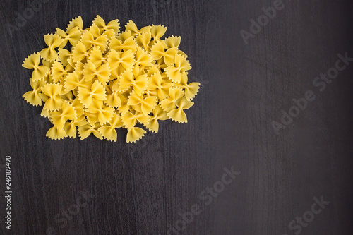 A pile of farfalle pasta on black background with copyspace
