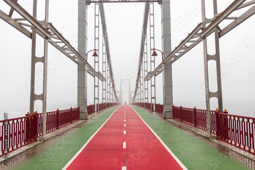 beautiful pedestrian bridge, red and green. on fog background