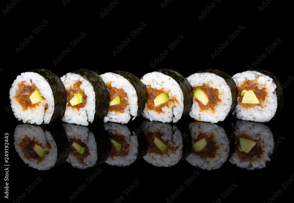 Futomaki sushi with spicy tuna and avocado on a black background Futomaki sushi with spicy tuna and avocado on a black background