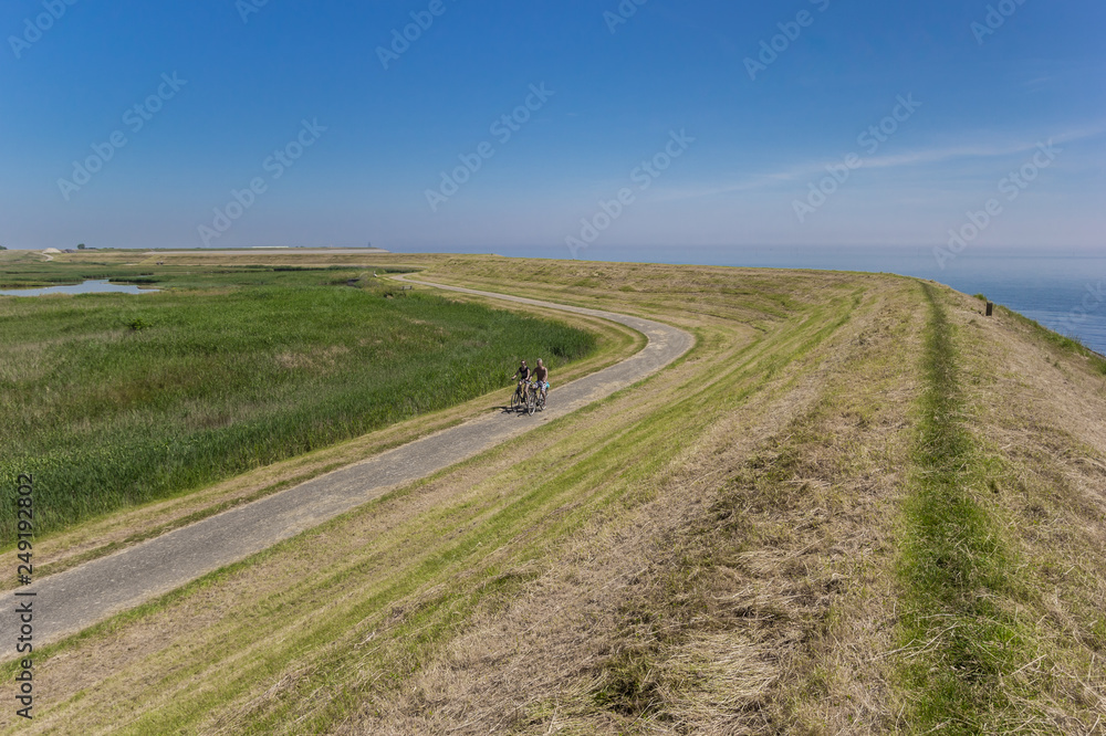 Couple on bicycles along a dike on Texel island, Netherlands