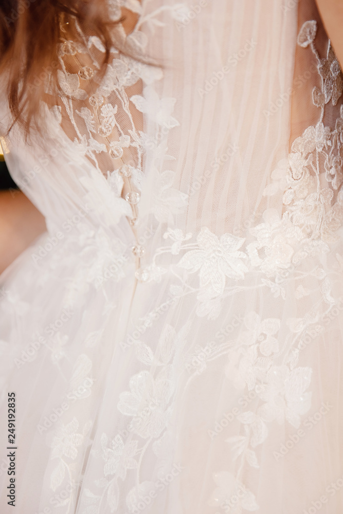 Photo from back Beautiful young woman in white wedding dress smiling Photo from back Beautiful young woman in white wedding dress smiling