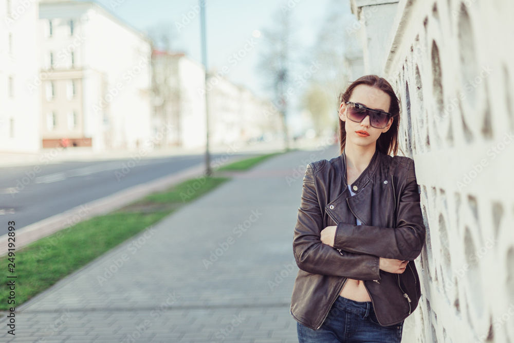 Street hipster portrait of young cheerful girl posing outdoors in summer in sun glasses. Happiness, leisure, beauty, stylish concept Street hipster portrait of young cheerful girl posing outdoors in summer in sun glasses. Happiness, leisure, beauty, stylish concept