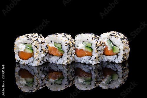 Uramaki Sushi with salmon and philadelphia on a black background