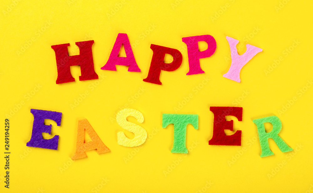 Easter concept. Inscription in colored letters Happy Easter on a yellow background.Top View. Flat Lay Easter concept. Inscription in colored letters Happy Easter on a yellow background.Top View. Flat Lay
