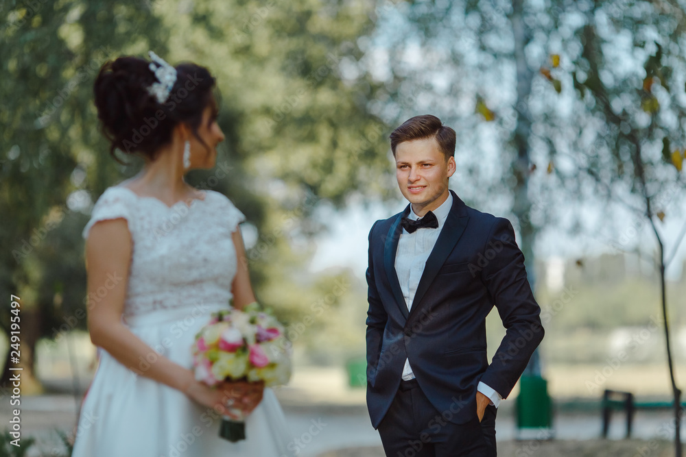 Wedding couple embracing a green park in daylight. Wedding couple embracing a green park in daylight.