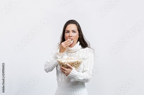 beautiful young woman in a studio eating popcorn