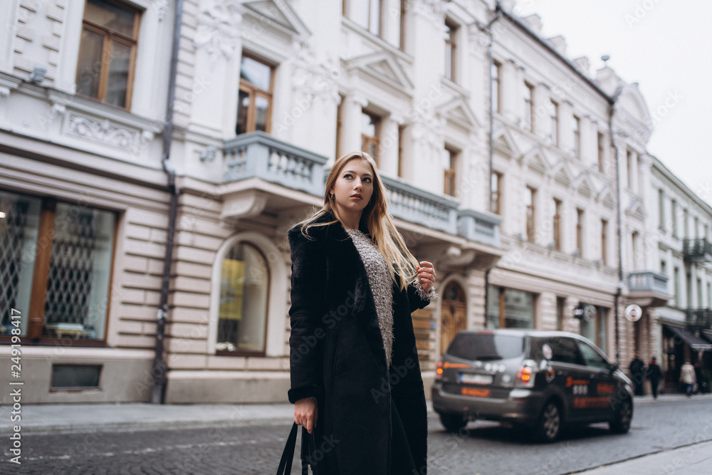 Young blondie business woman rushing to a business meeting. Walking along old historic european town Young blondie business woman rushing to a business meeting. Walking along old historic european town