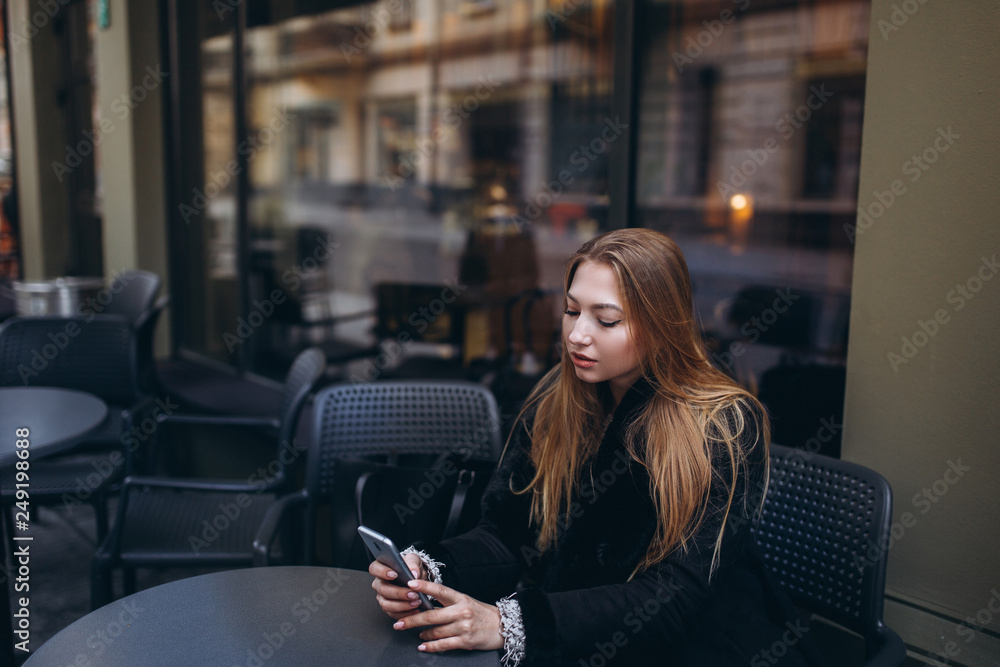 Blondie young girl in street outdoor cafe with smartphone chating and communicate Blondie young girl in street outdoor cafe with smartphone chating and communicate