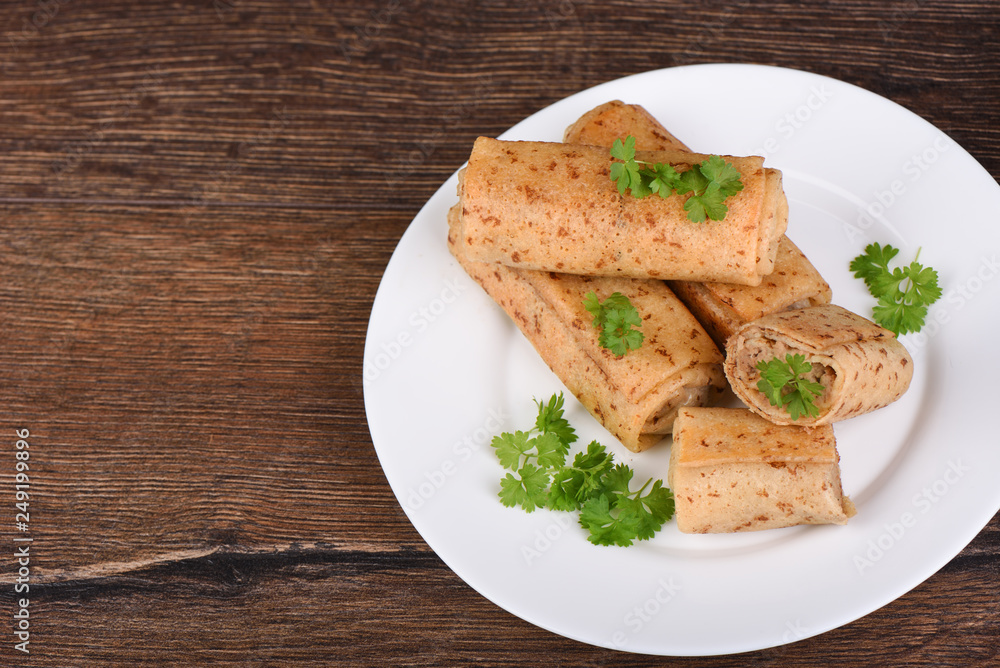 Pancake rolls with meat filling, served with fresh parsley Pancake rolls with meat filling, served with fresh parsley