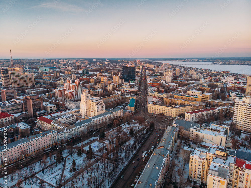 Aerial shot of winter Voronezh midtown at sunset evening time, old city architecture buildings, roads and car traffic