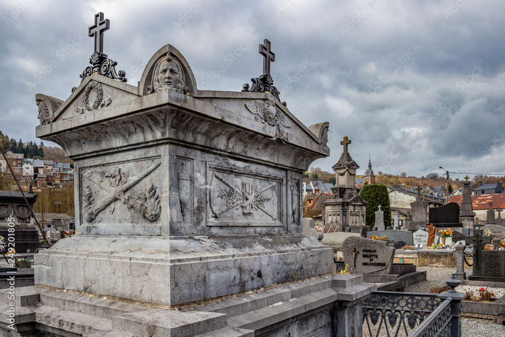 Old tomb at Stavelot cemetery under a moody overcast March sky, at Stavelot, Belgium Old tomb at Stavelot cemetery under a moody overcast March sky, at Stavelot, Belgium