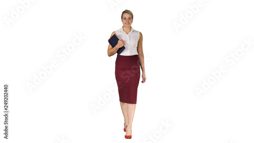 The woman holding the books walking to the camera on white background.