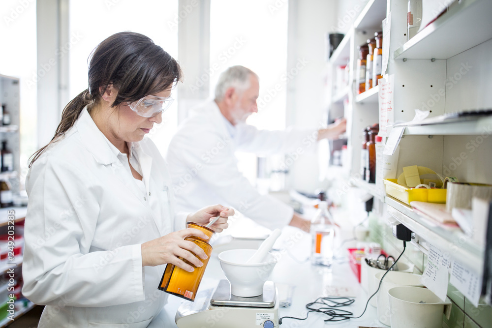 Man and woman working in laboratory of a pharmacy Man and woman working in laboratory of a pharmacy