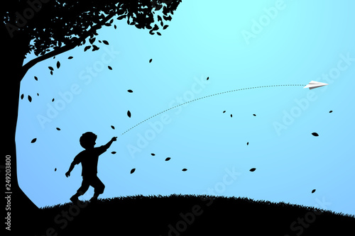 silhouette of boy running to throw out origami paper airplane under the tree. Concept of children play and learn.