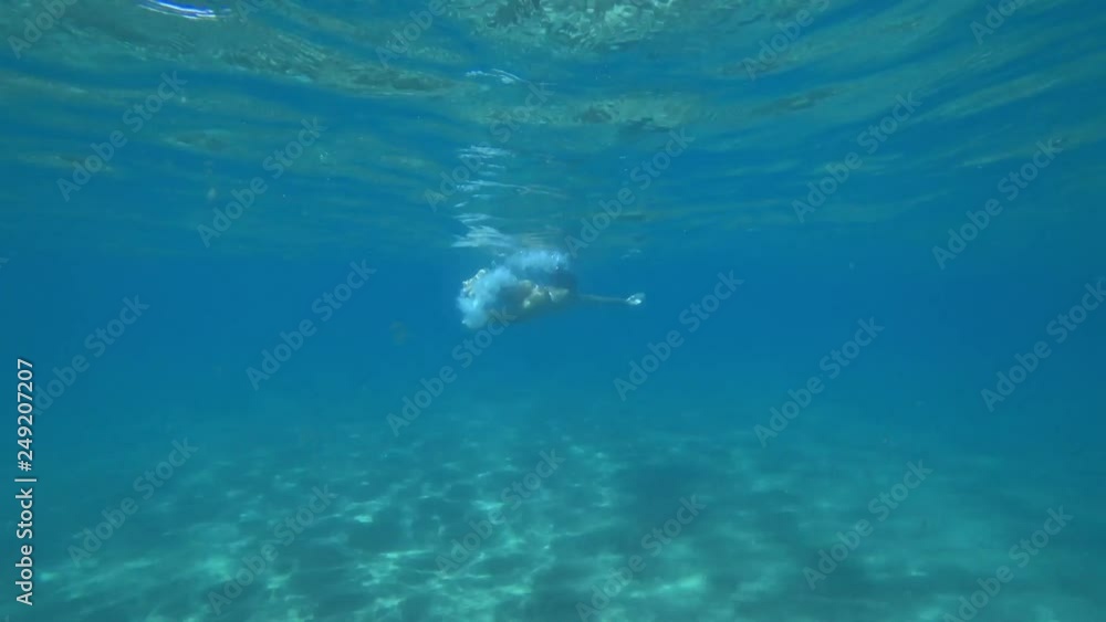 Underwatershot of young caucasian woman swimming in the ocean Underwatershot of young caucasian woman swimming in the ocean