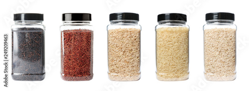Set of plastic jars with different uncooked rices on white background
