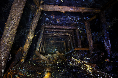 Fototapeta Naklejka Na Ścianę i Meble -  Abandoned mine with rotten wooden miner stands. Old derelict development in coal field