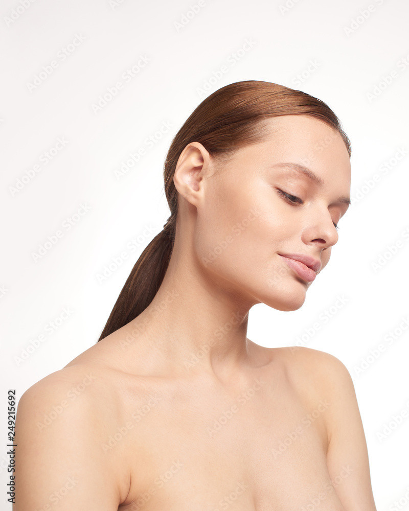 Beauty portrait of young girl with brown hair and big lips on white background with clean face skin and arm near head. Good for cosmetic, medicine and spa . European type Beauty portrait of young girl with brown hair and big lips on white background with clean face skin and arm near head. Good for cosmetic, medicine and spa . European type