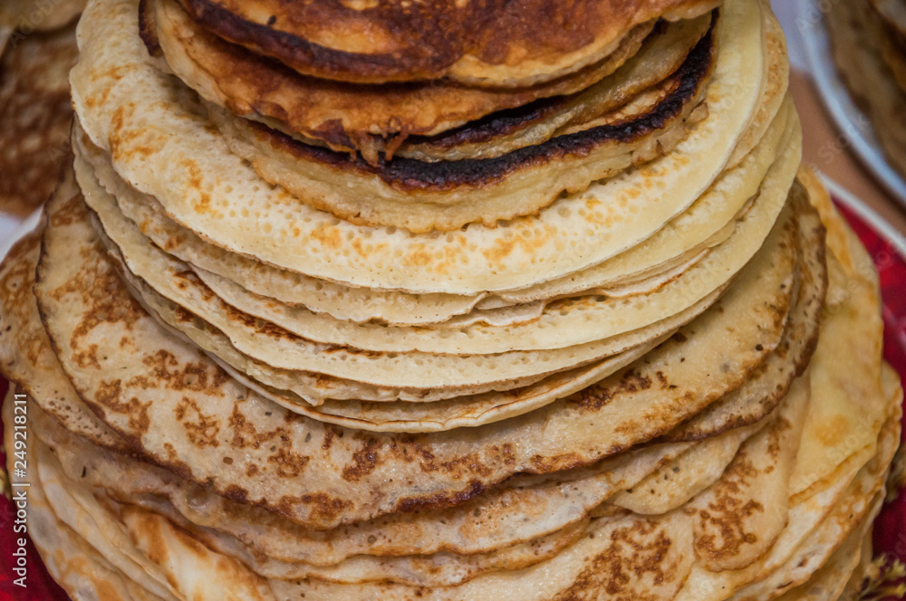 Very large stack of pancakes in the contest during the celebration Russian Shrovetide (pancake week) at school