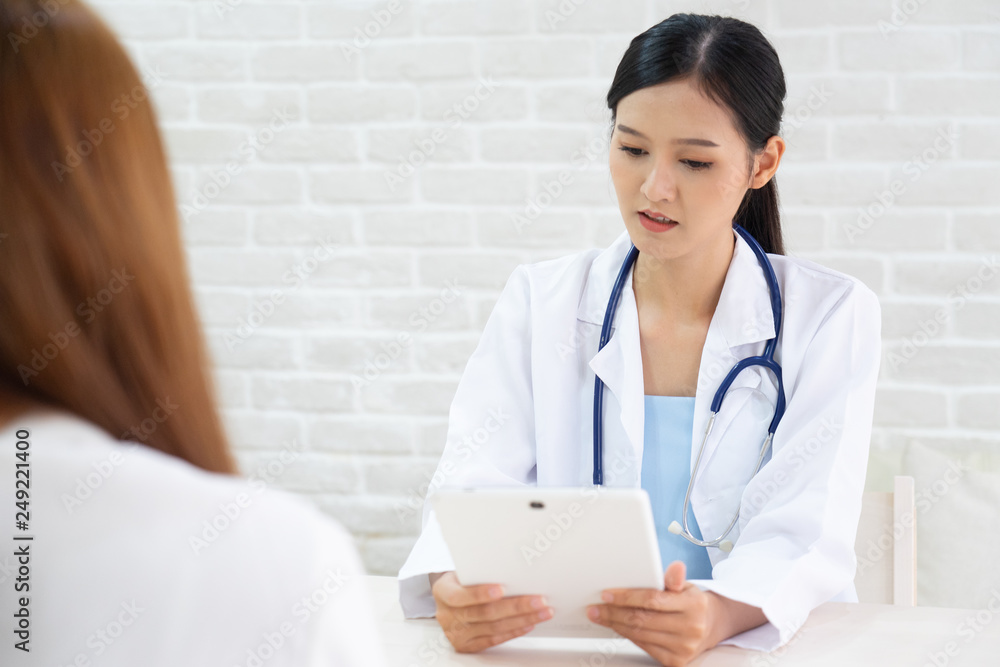 Female doctor talking to patient.Doctor and patient discussing something while sitting at the table . Medicine and health care concept. Doctor and patient Female doctor talking to patient.Doctor and patient discussing something while sitting at the table . Medicine and health care concept. Doctor and patient