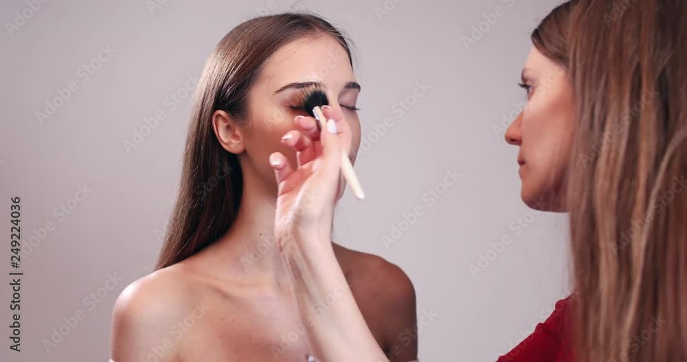 Make up artist doing make up of beautiful young woman Make up artist doing make up of beautiful young woman