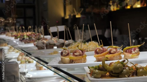 Showcase window display assortiment with tapas – traditional Spanish sandwiches in a cafe in Barcelona, Spain close up macro