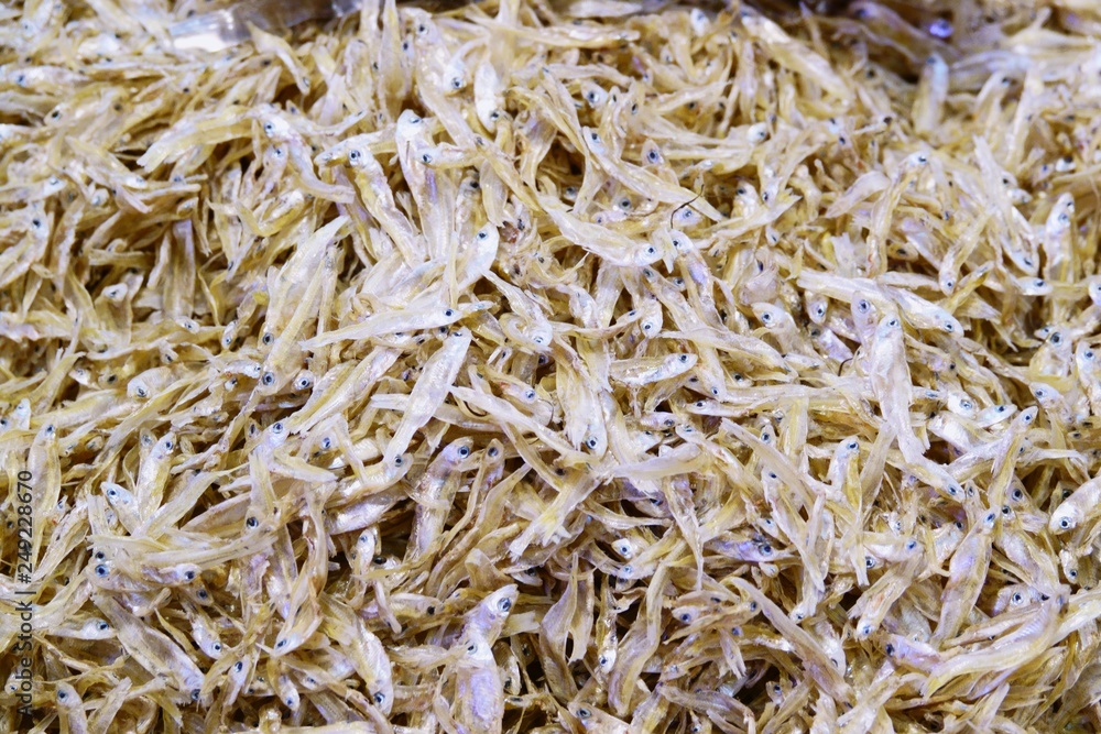 Piles of dried anchovies on the shelves close up