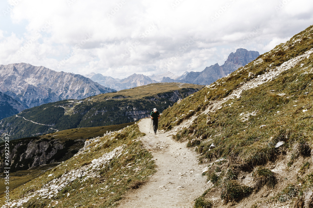 Wanderer wandert in den Bergen einen Trampelpfad entlang