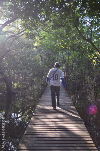 Male tourists walk on the wooden bridge.